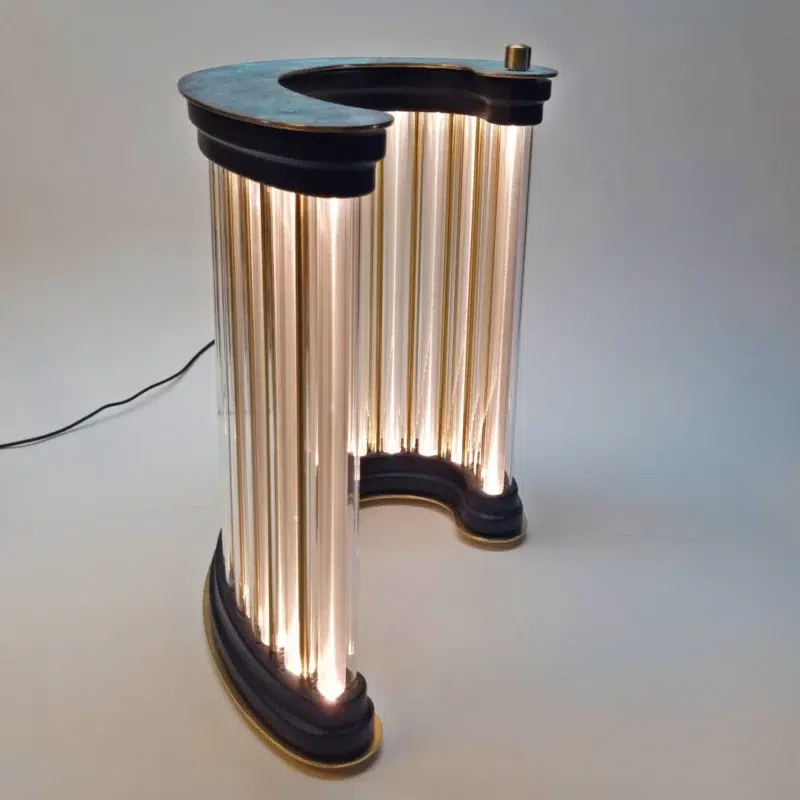 Single luminous column sculpture made of brass, wood, and ribbed plexiglass.