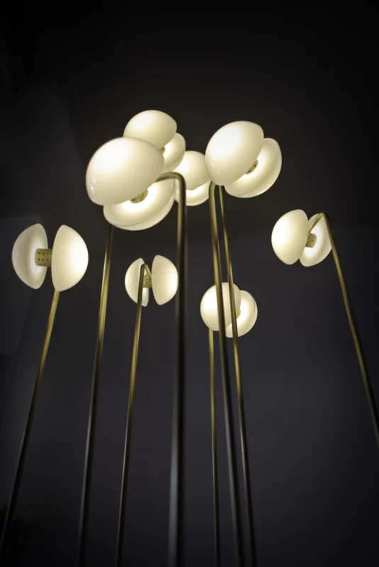 Upward view of Germes de Lux luminous sculpture, with seed-like lights on tall brass stems