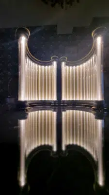 Inside perspective of the two golden columns of Limen, glowing with warm light.