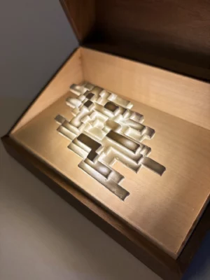 Vapor Minimus illuminated inside an open walnut box, angled view.
