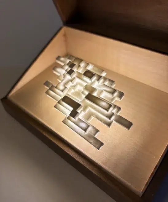 Vapor Minimus illuminated inside an open walnut box, angled view.