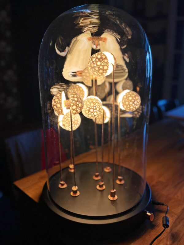 Full view of the Germes de Lux Atlantis sculpture under a glass dome, with glowing porcelain spheres on copper stems.